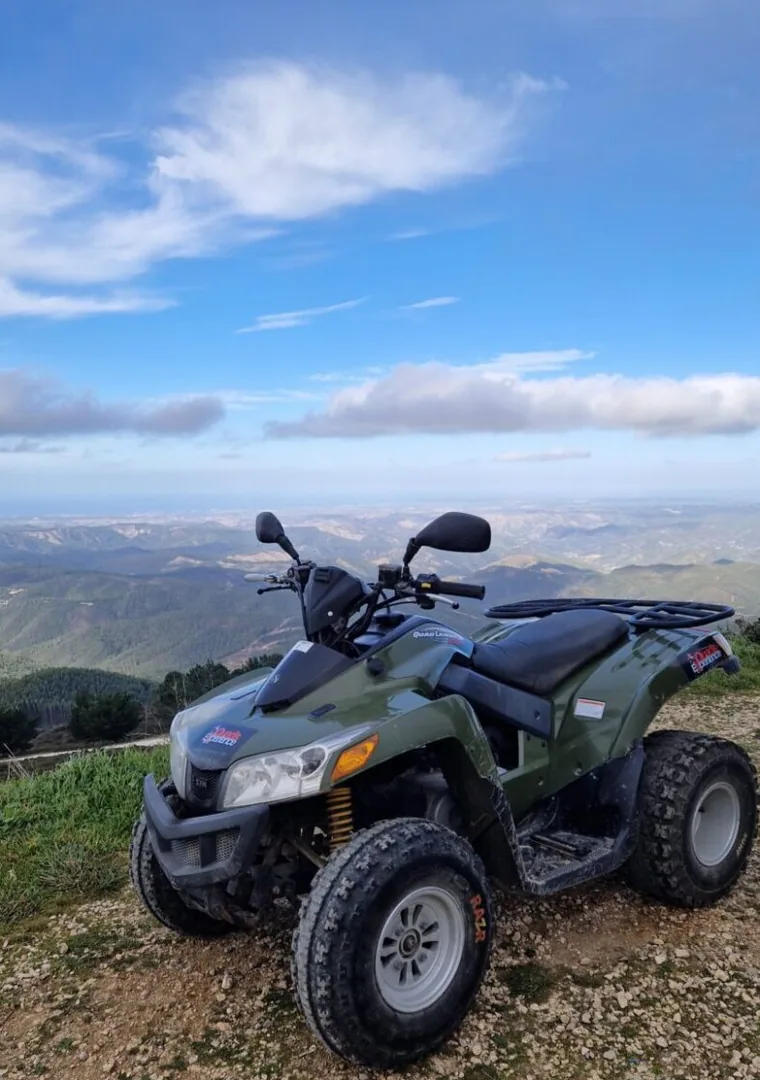 A quad parked at a mountain viewpoint